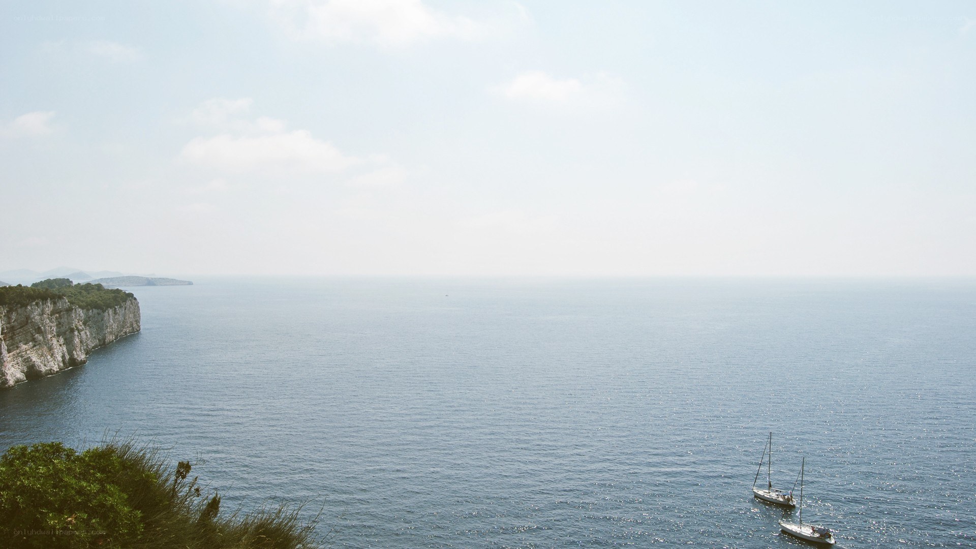 Coastal cliffs and sailboats