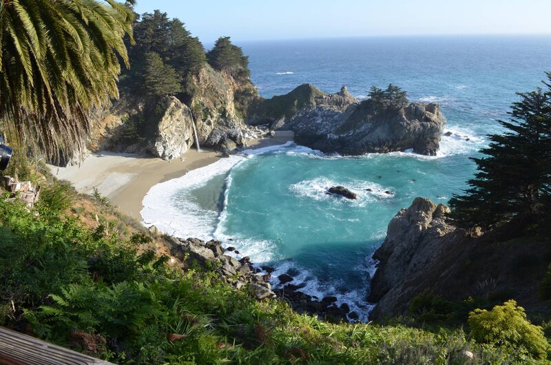 Coastal Cove with Waterfall — Blue, Serene, Afternoon, Photograph, Palm Tree
