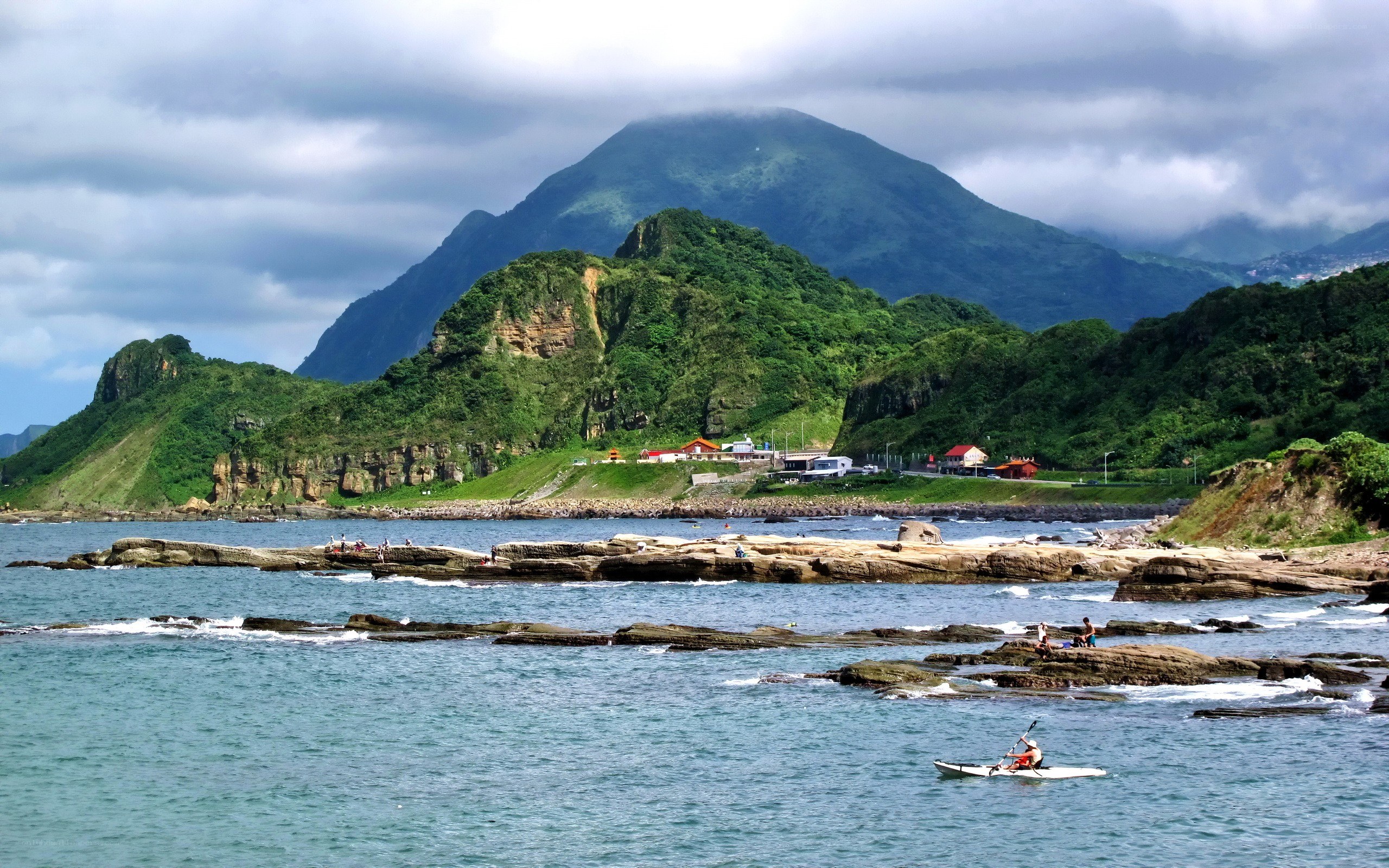 coastal kayaking with mountain backdrop