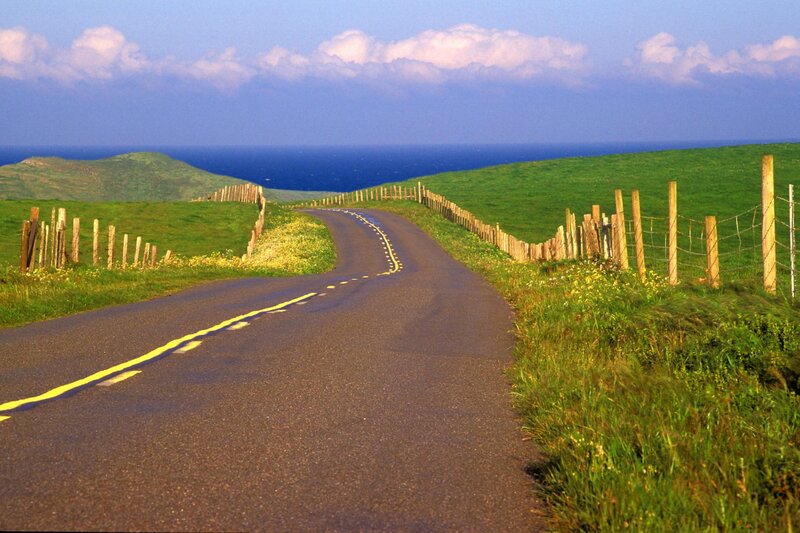 Coastal road winding through green hills