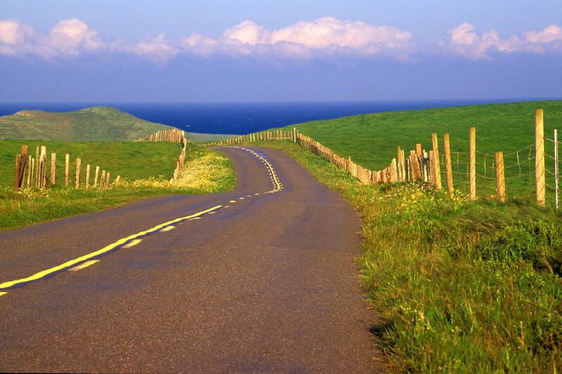 Coastal road winding through green hills