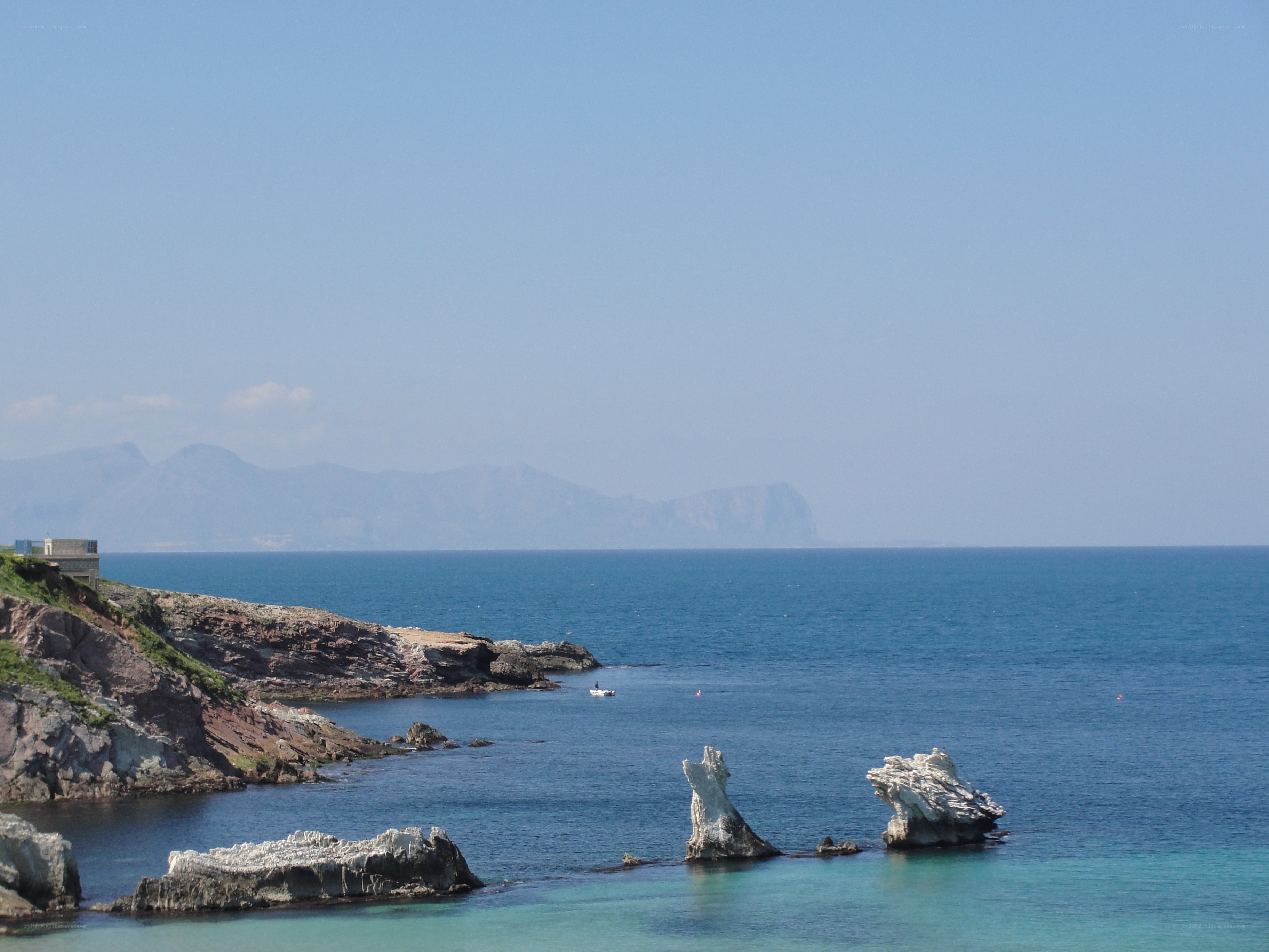 coastal rocks and distant mountains