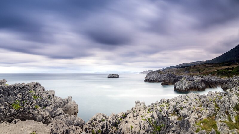 coastal rocks under cloudy sky