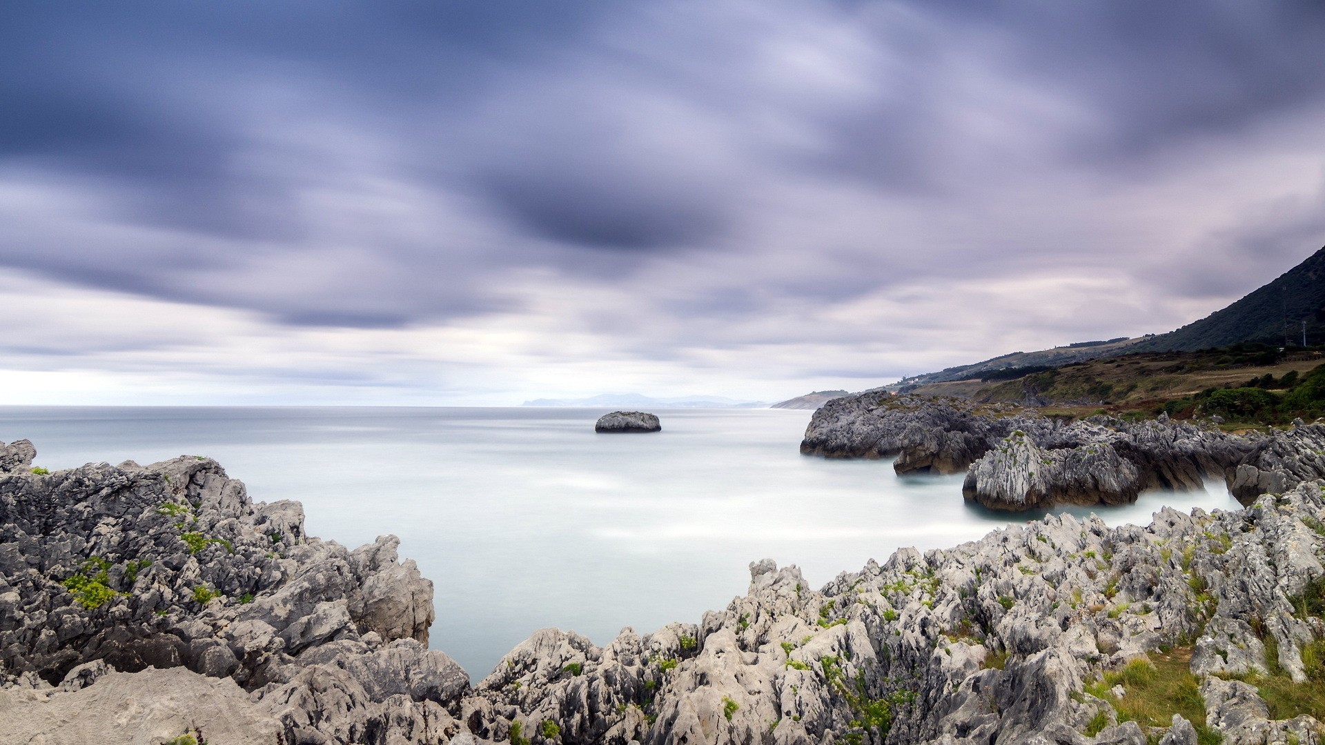 coastal rocks under cloudy sky