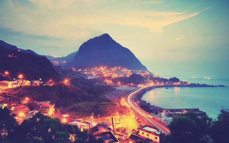 Coastal town at dusk with mountain view