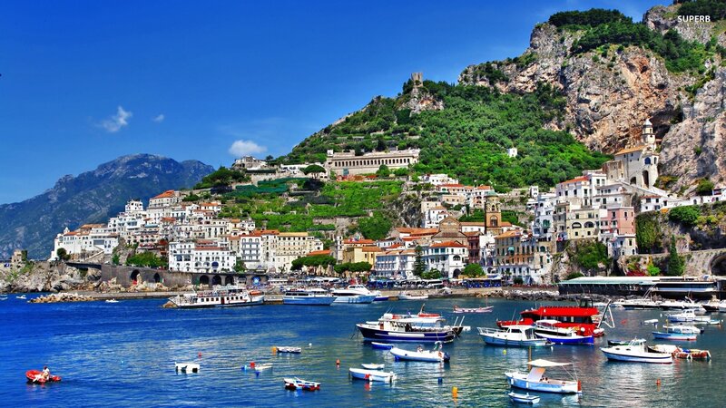 Coastal town with boats and cliffs