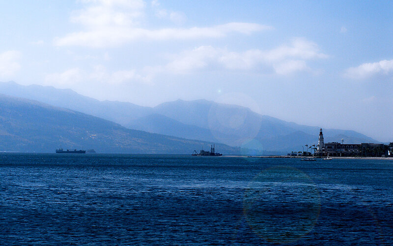 coastal view with mountains and lighthouse