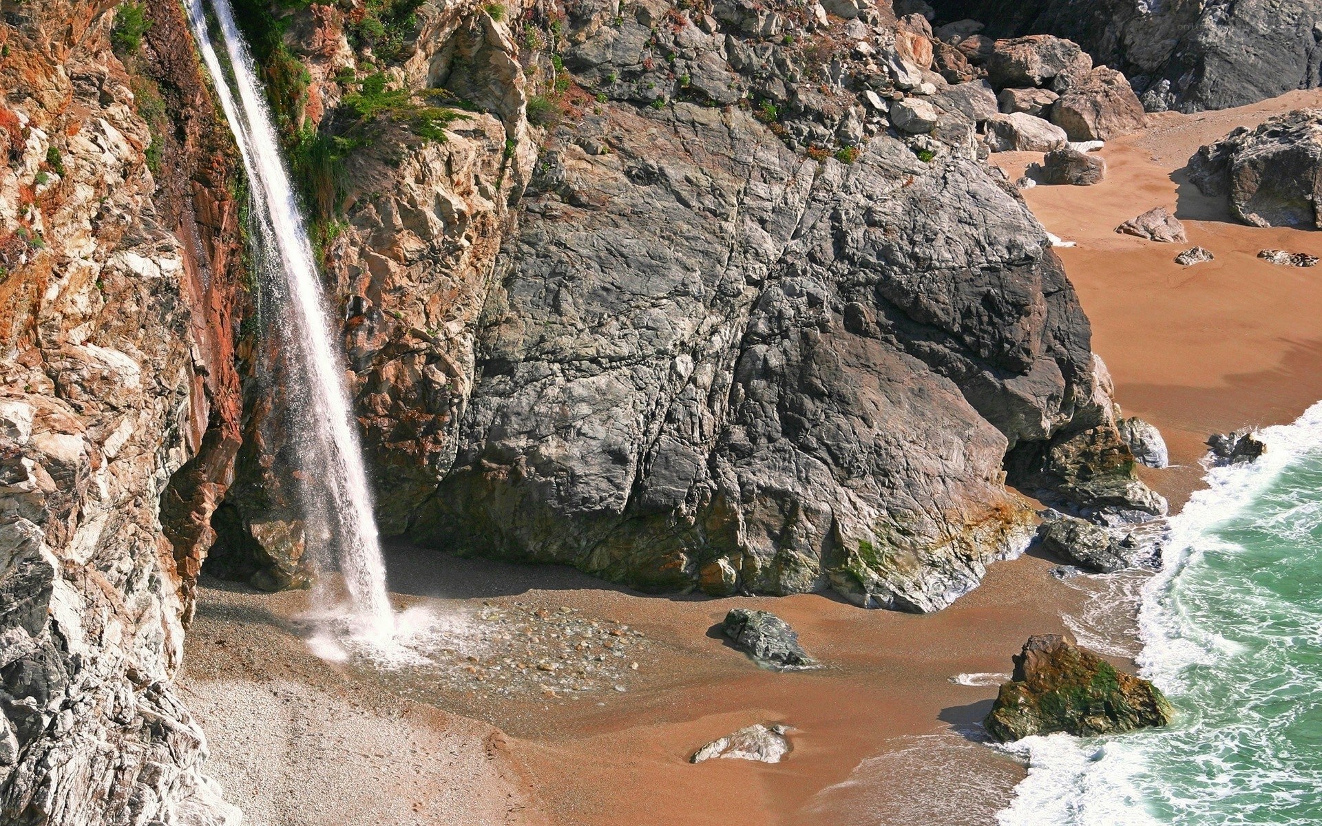 coastal waterfall on rocky beach