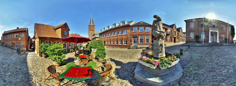 Cobblestone square with fountain and red tables