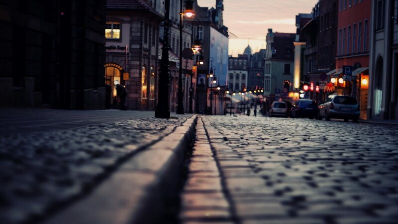 Cobblestone Street at Dusk — Gray, Calm, Sunset, Photograph, Buildings, Cars, Streetlights, Orange