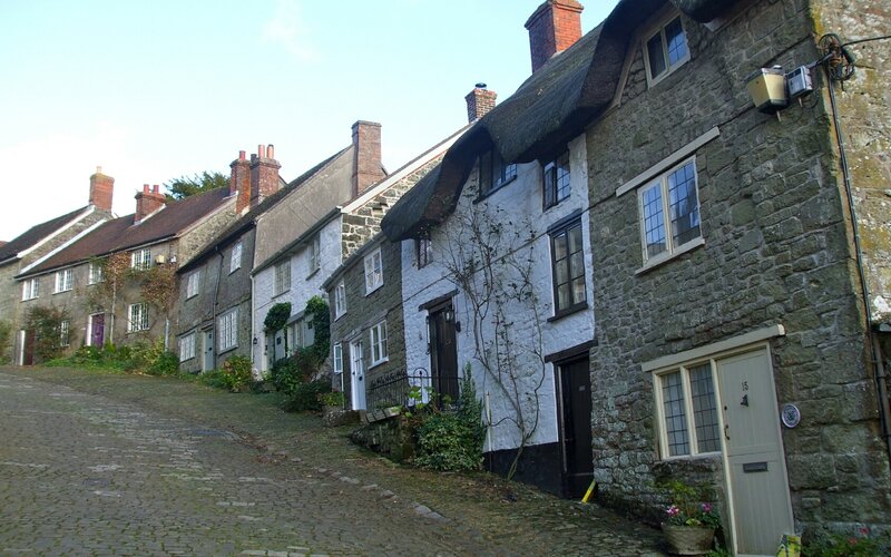 Cobblestone street with thatched cottages