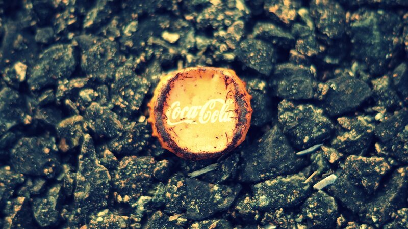 Coca-Cola bottle cap on gravel