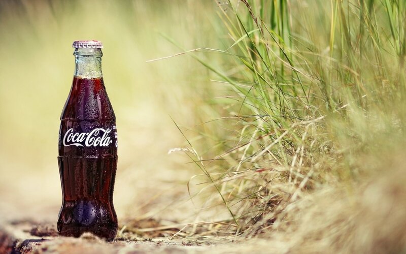 Coca-Cola Bottle in Grass — Green, Serene, Afternoon, Photograph, Dirt