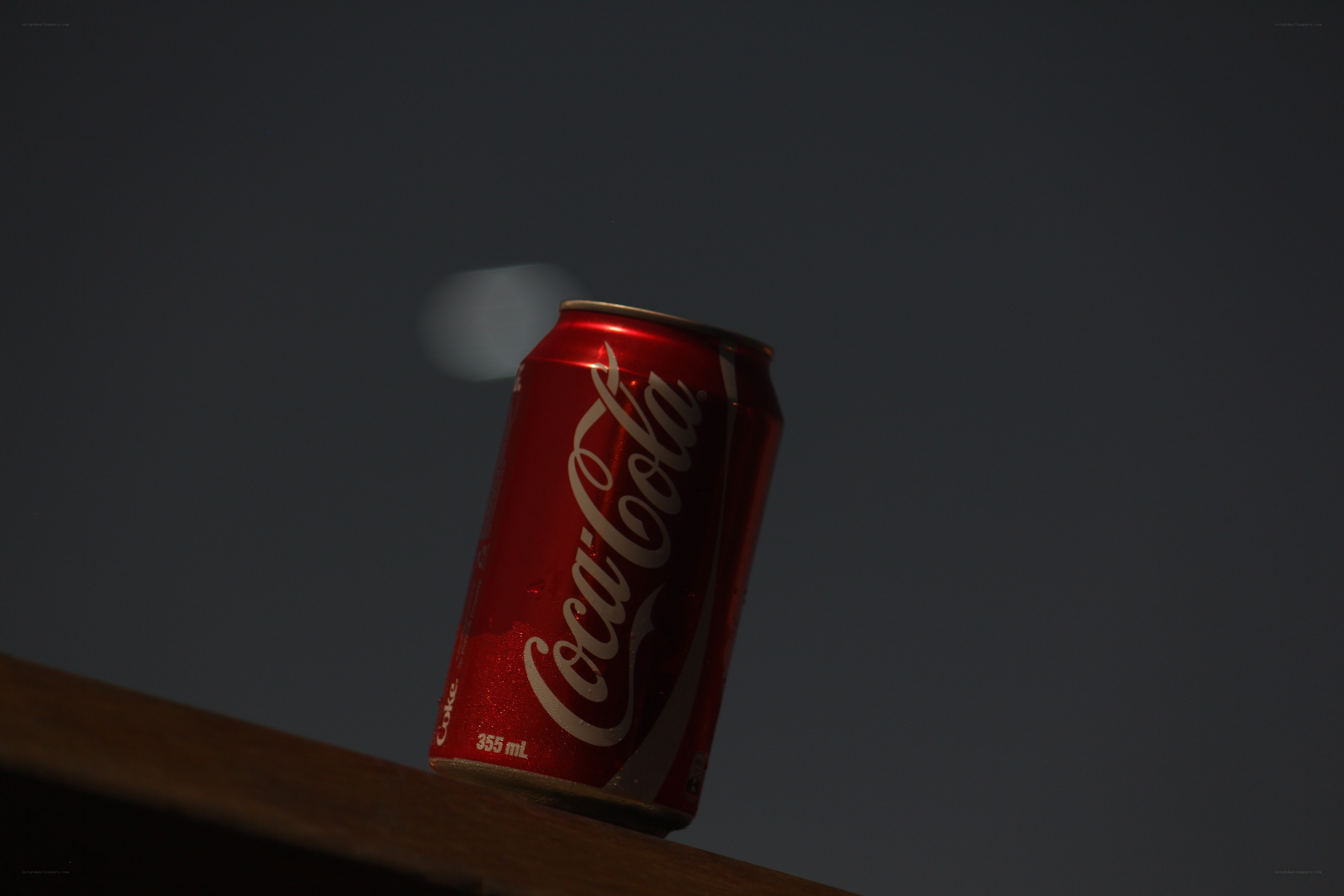 Coca-Cola can on wooden surface