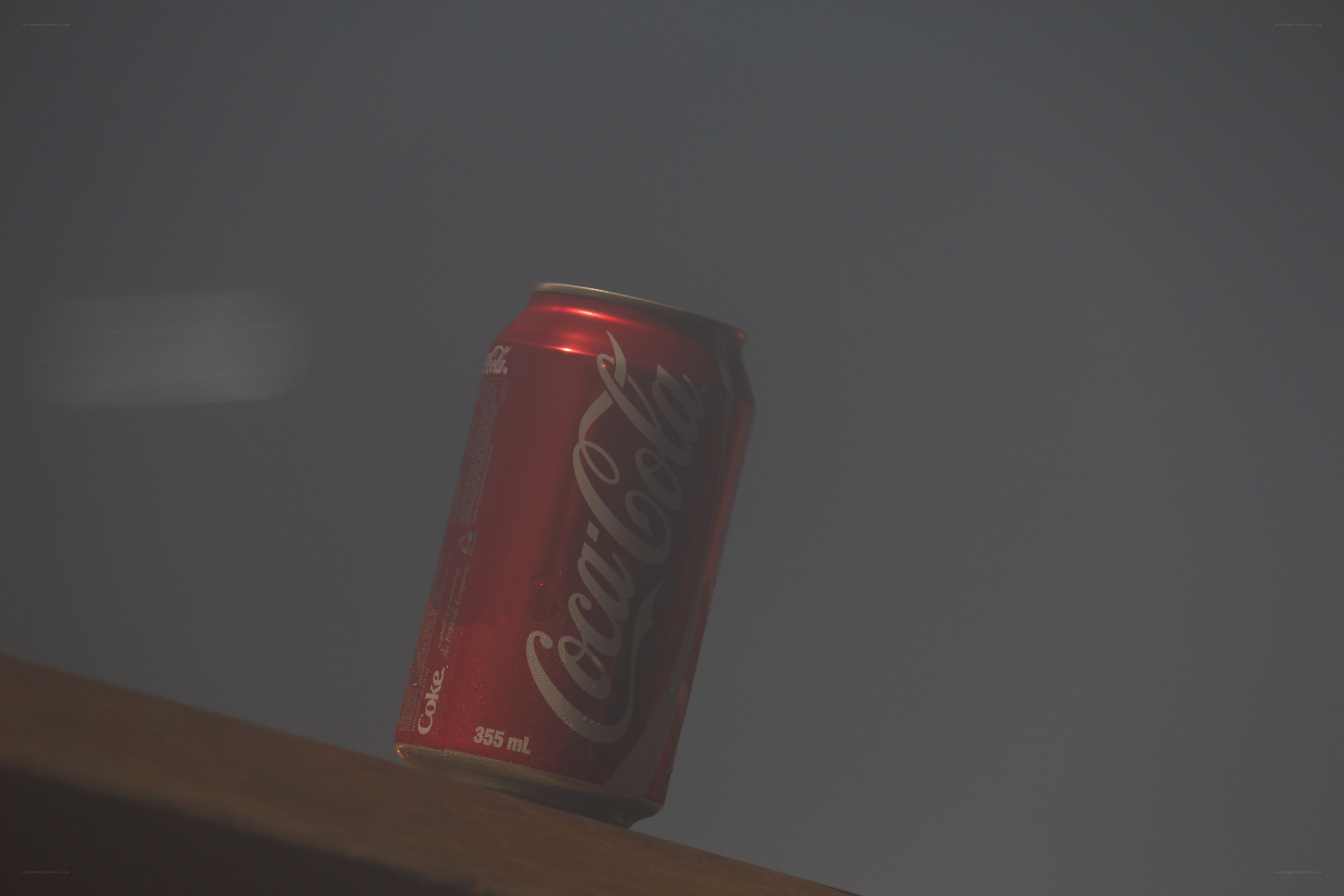 Coca-Cola can on wooden surface