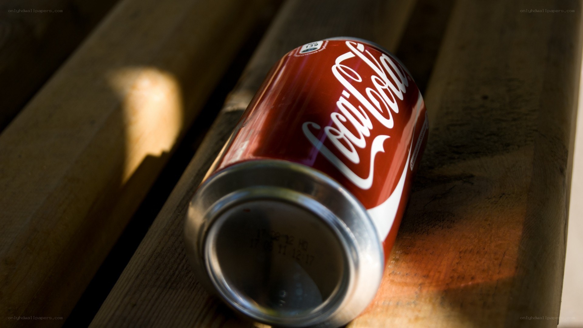 Coca-Cola can on wooden surface
