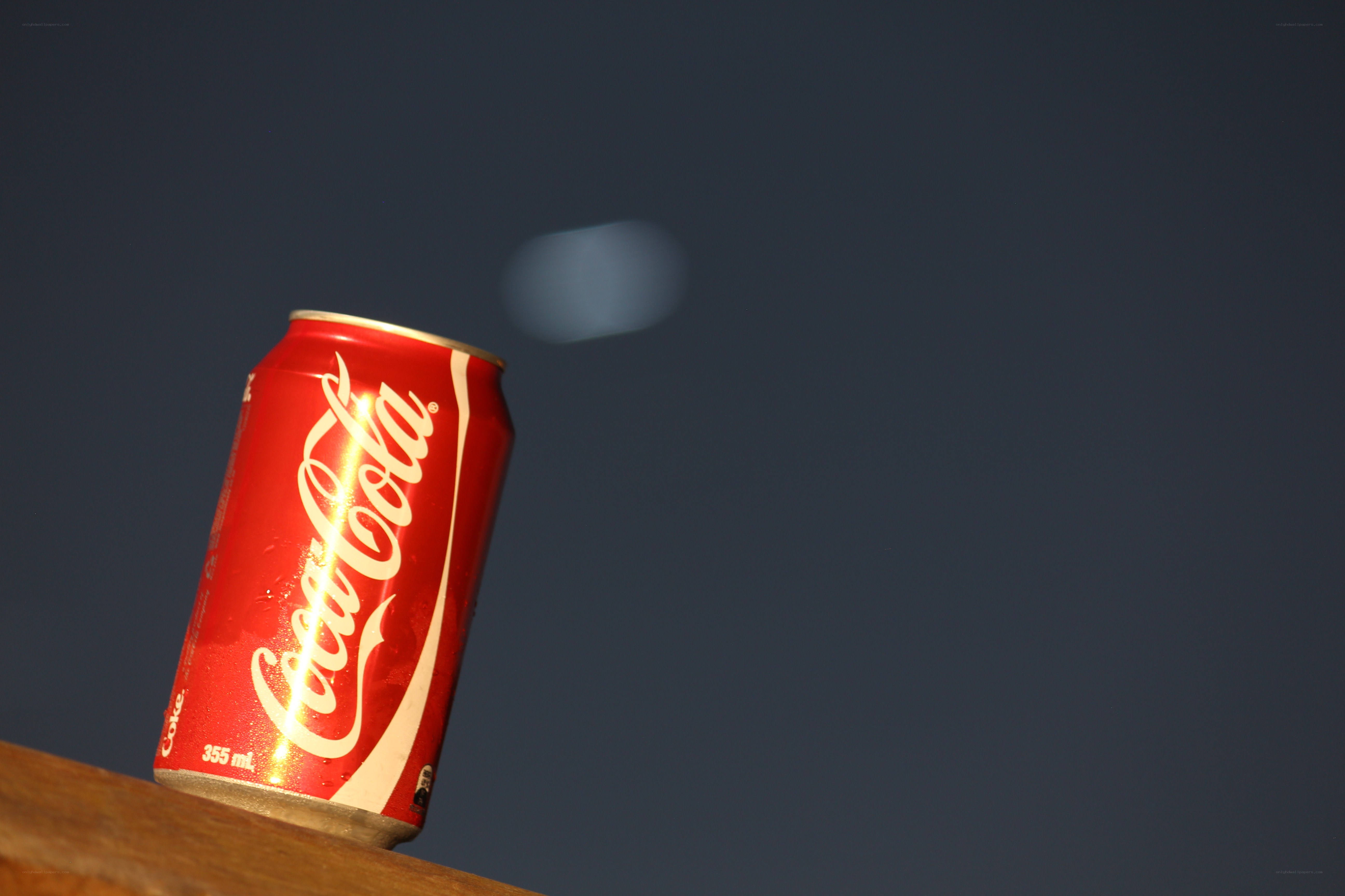 Coca-Cola can on wooden surface