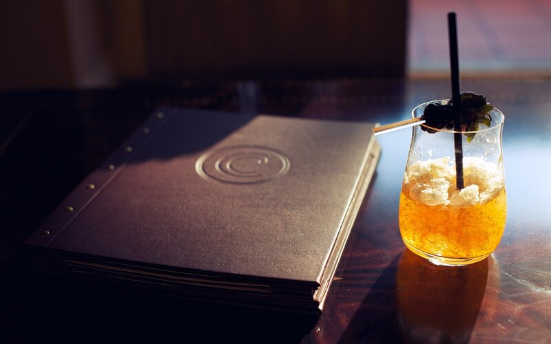 Cocktail and menu on a table