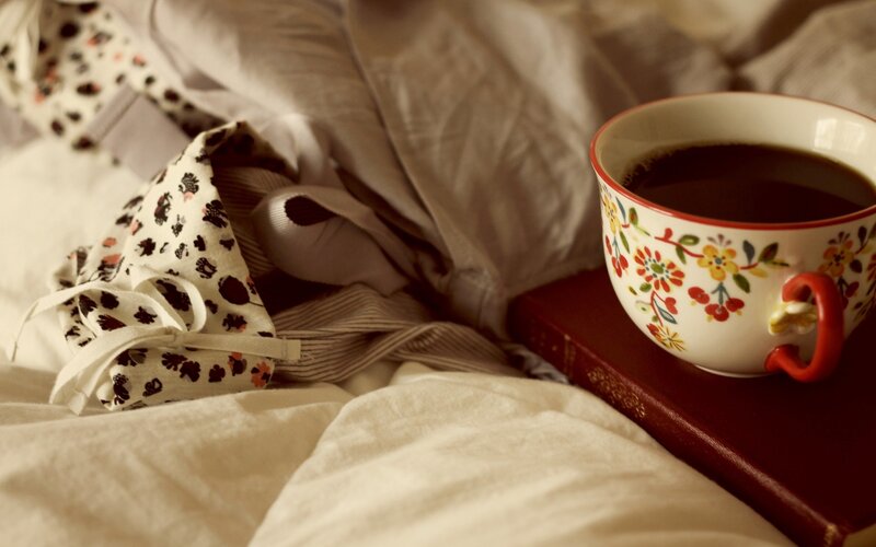 coffee and book on bed