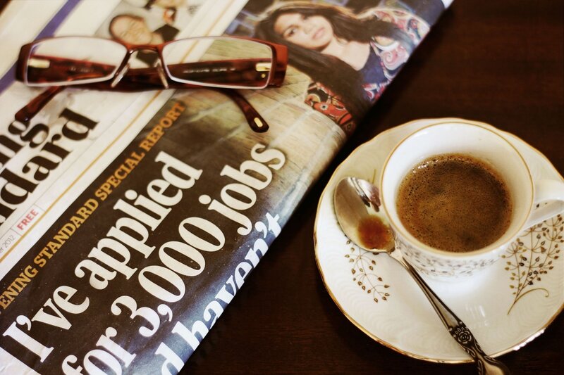 Coffee and newspaper on table