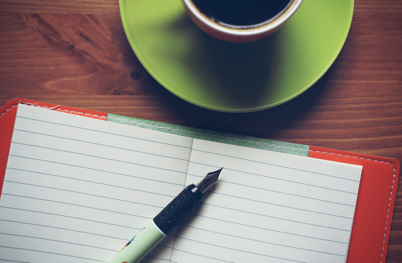 Coffee and notebook on wood