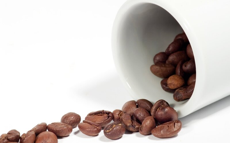 coffee beans spilling from cup