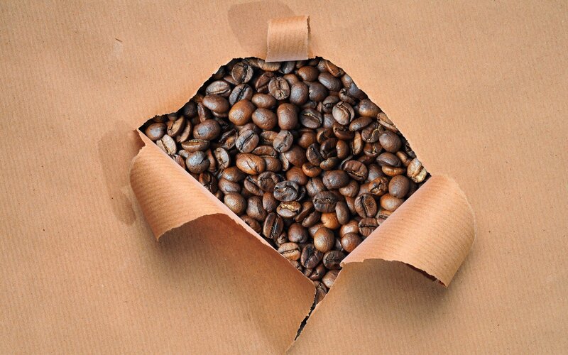 coffee beans through torn paper