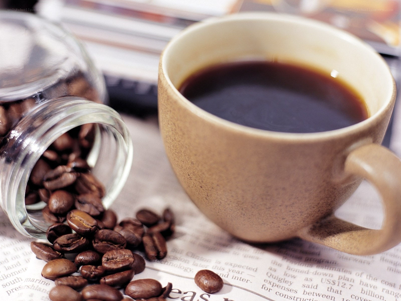 coffee cup with beans on newspaper