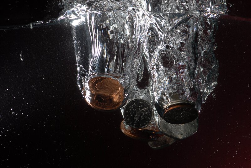Coins dropping into water