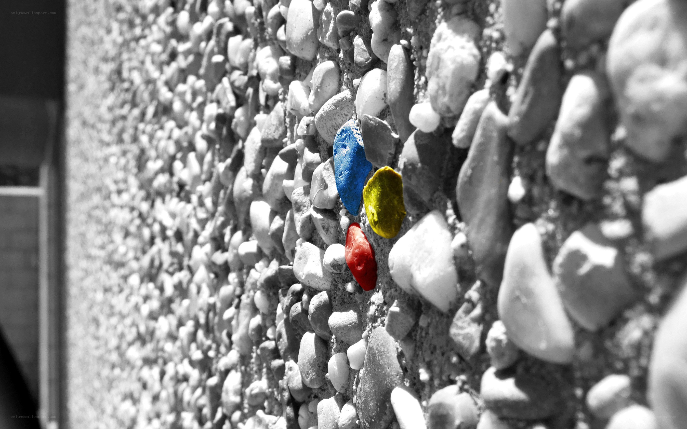 Colored stones on a pebble wall