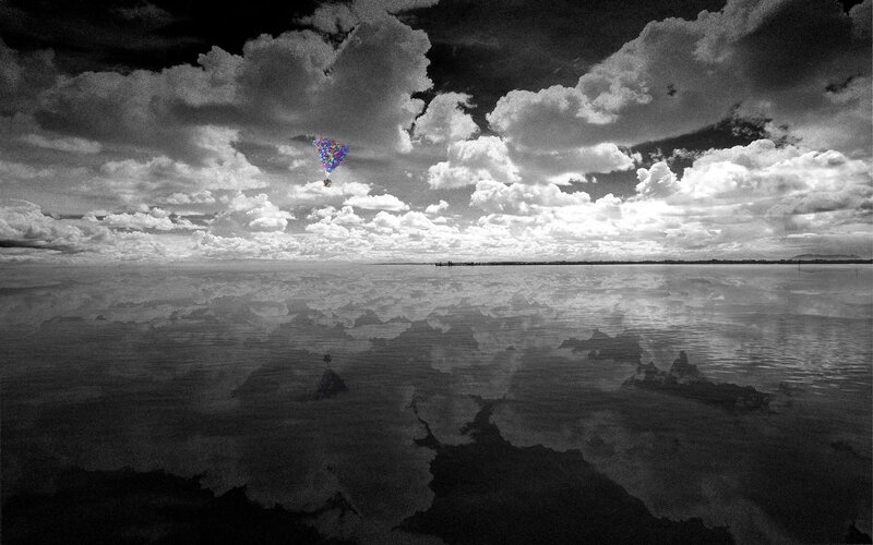Colorful balloons over a reflective lake