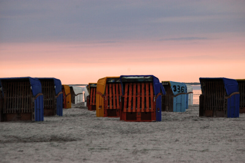 Colorful beach chairs at sunset