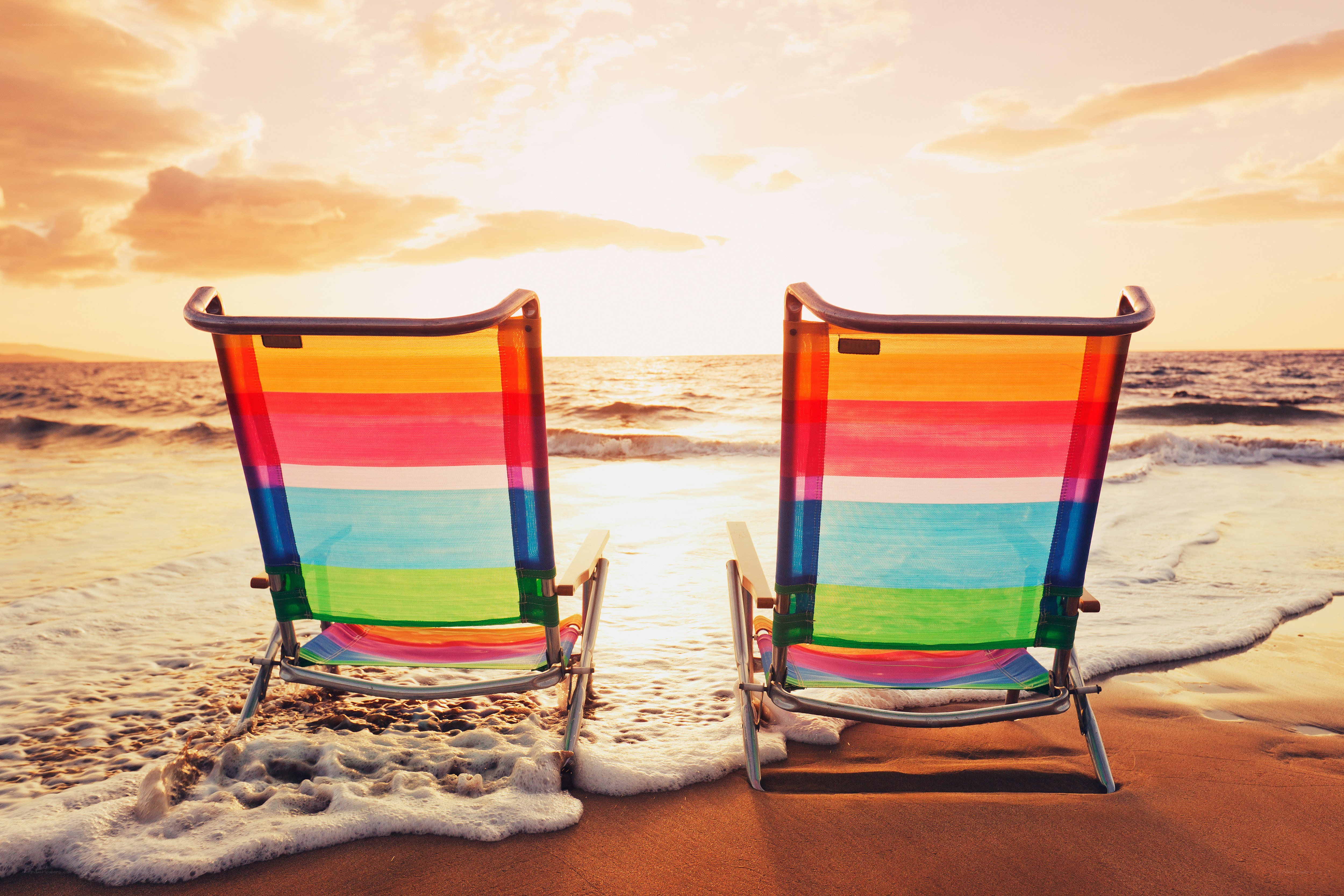 Colorful beach chairs at sunset
