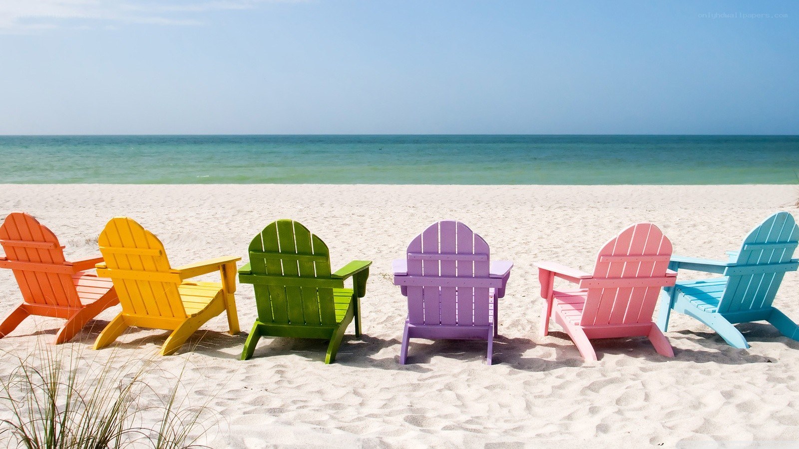 Colorful beach chairs on sand