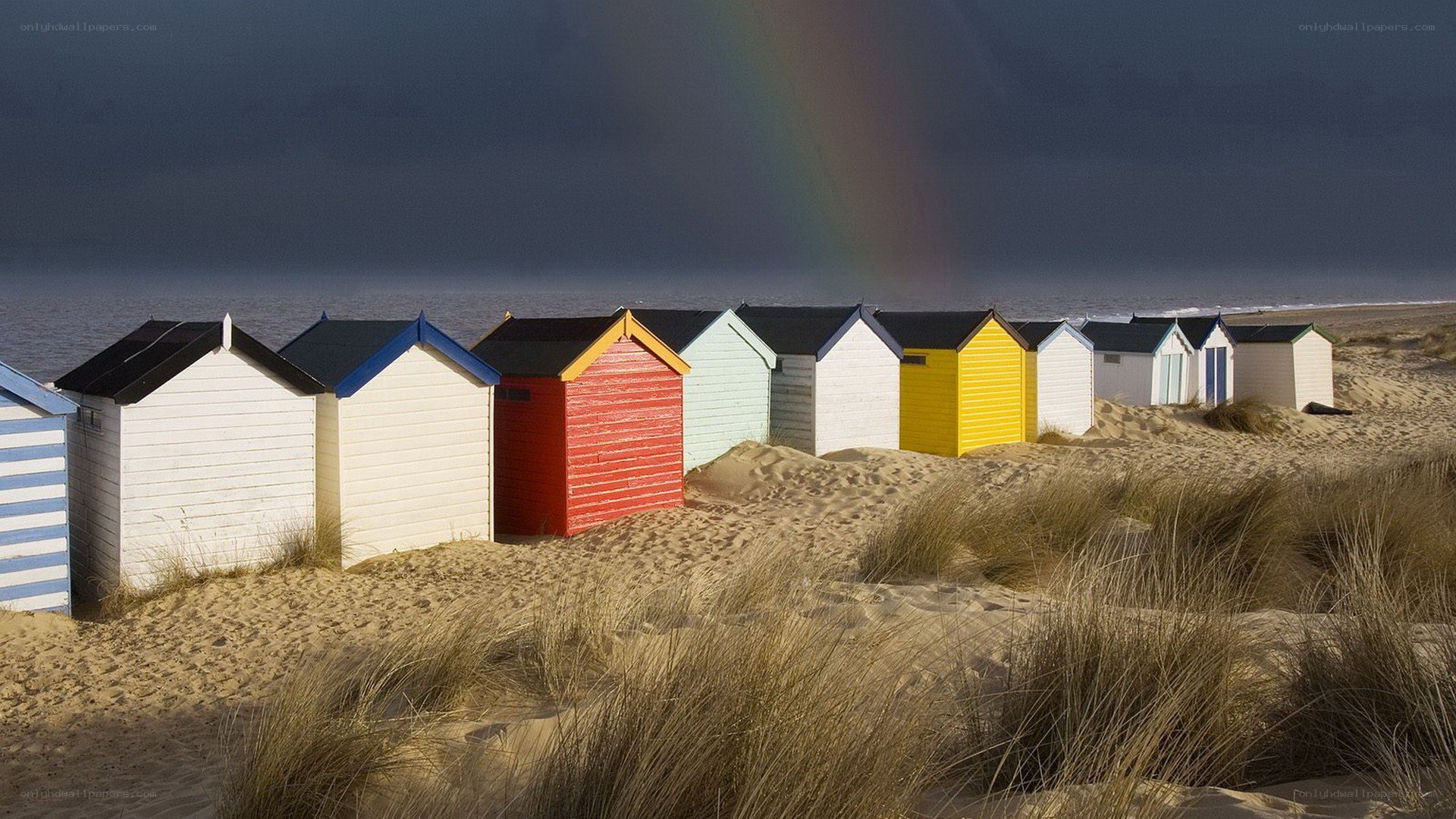 Colorful beach huts with rainbow