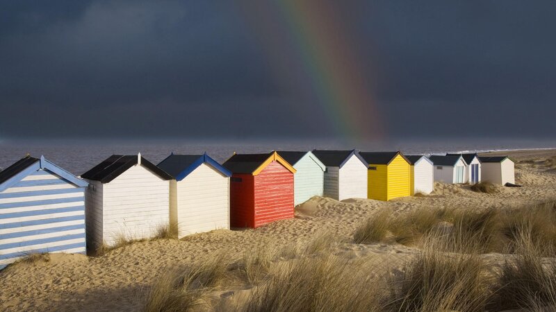 Colorful beach huts with rainbow