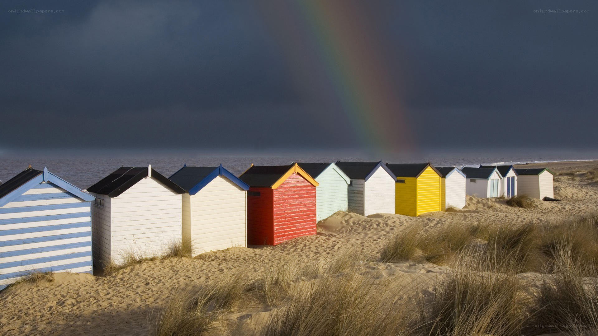Colorful beach huts with rainbow