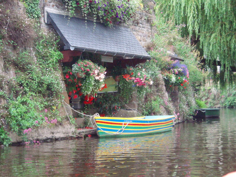 Colorful boat by flower-covered house
