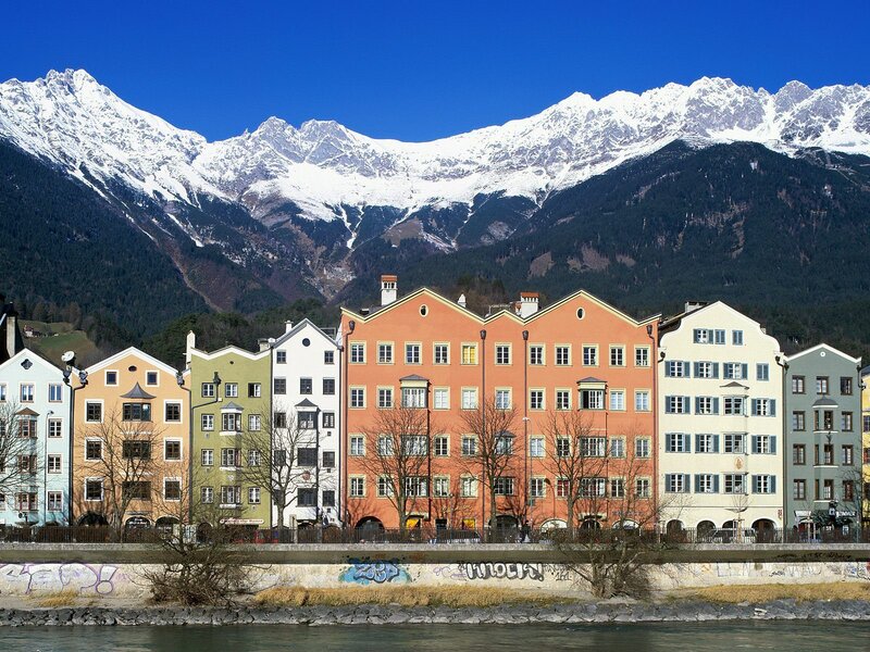 Colorful buildings by a river with mountains