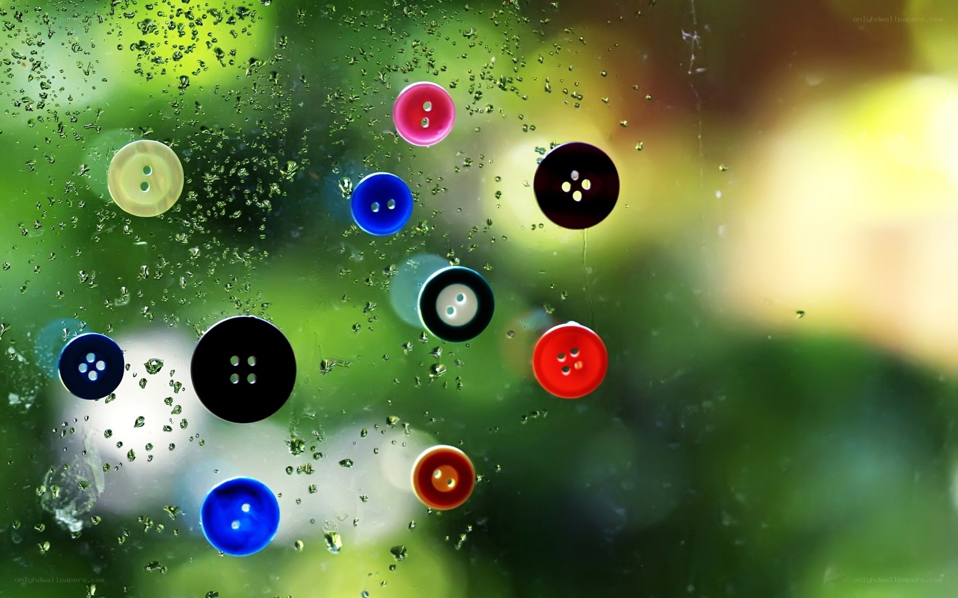 Colorful buttons on wet glass