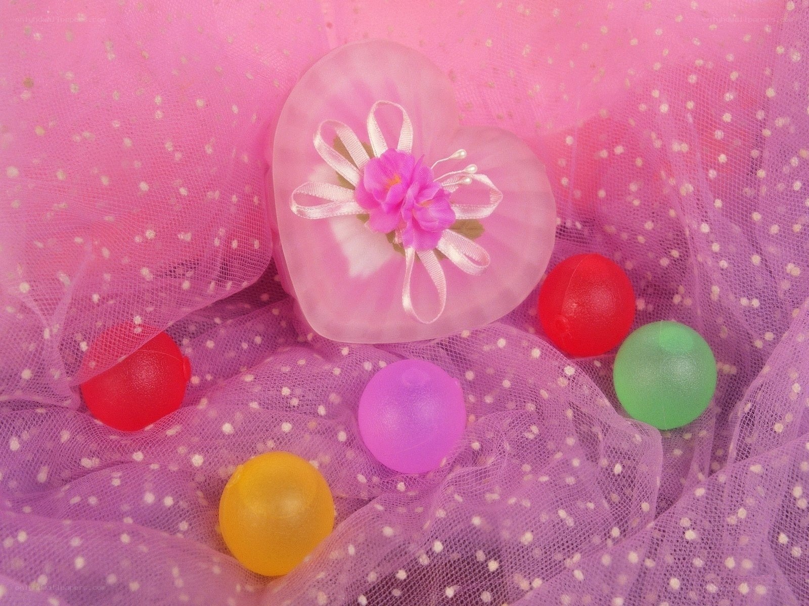 Colorful candies on pink fabric