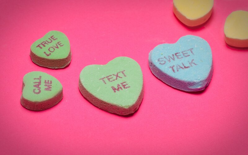 colorful candy hearts on pink