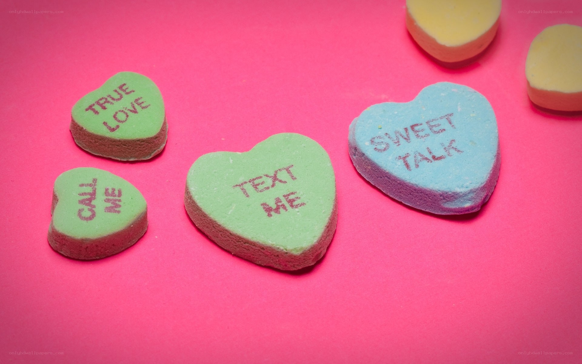 colorful candy hearts on pink