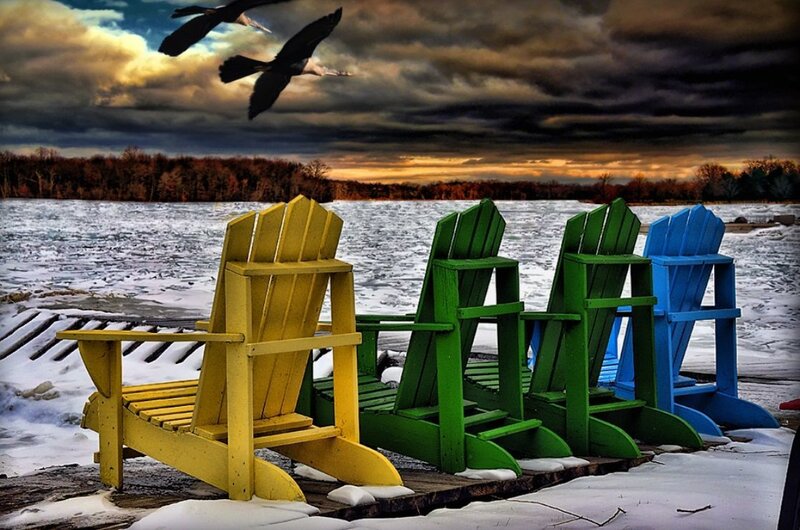Colorful chairs by a frozen lake