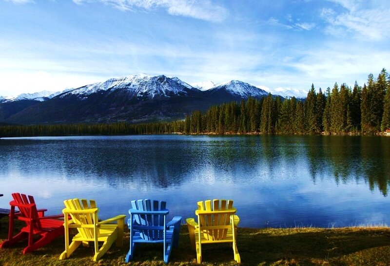 Colorful chairs by a mountain lake