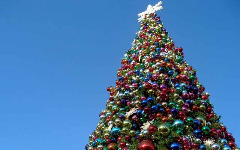 Colorful Christmas tree against blue sky