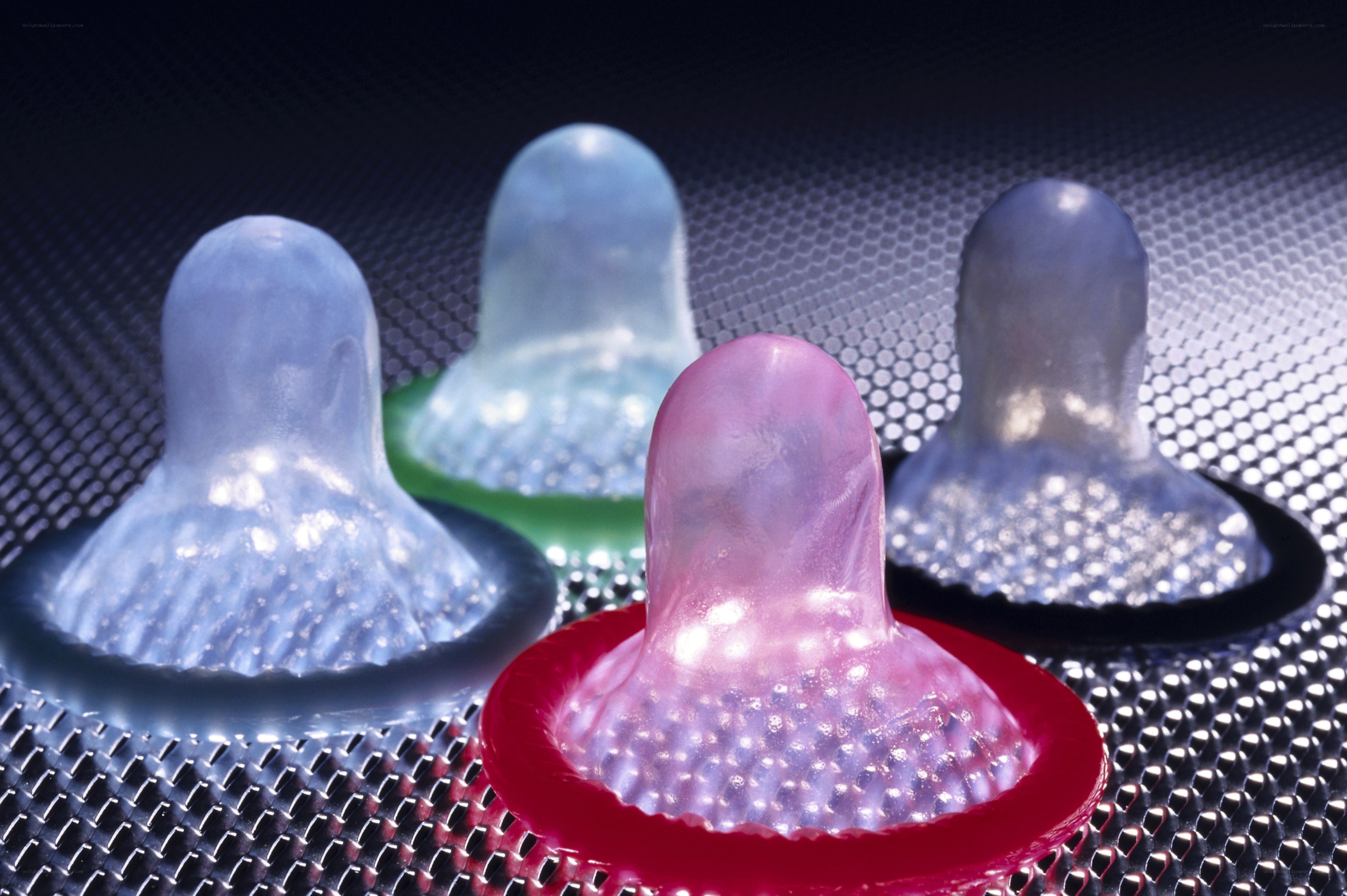 Colorful condoms on mesh surface