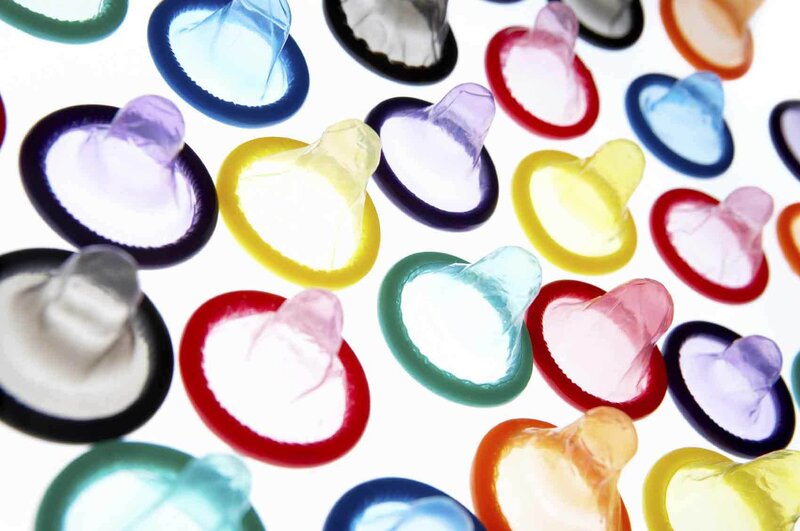Colorful condoms on white background