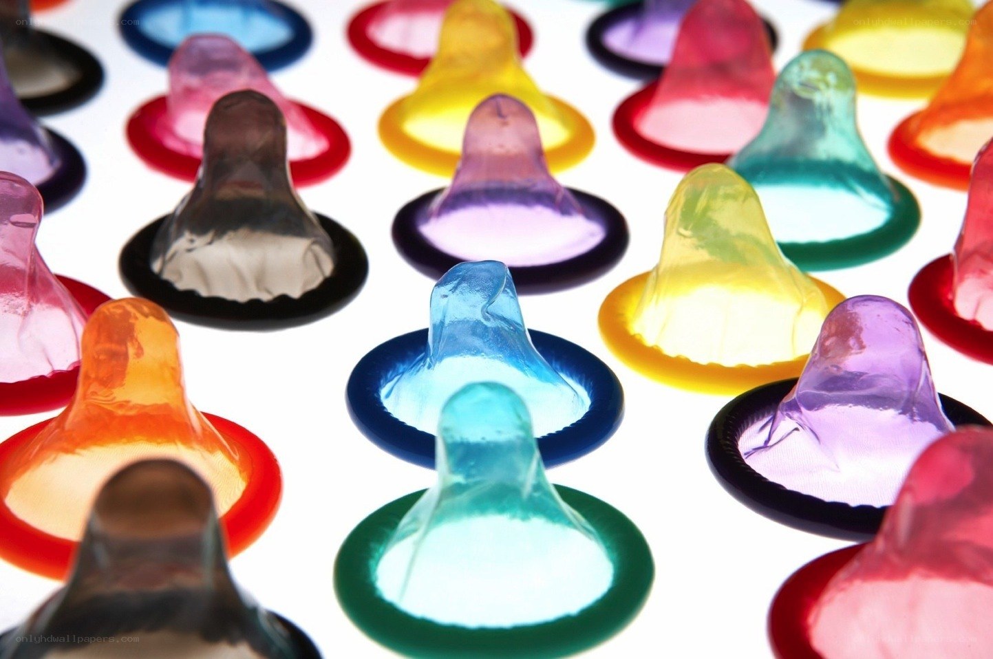 Colorful condoms on white background