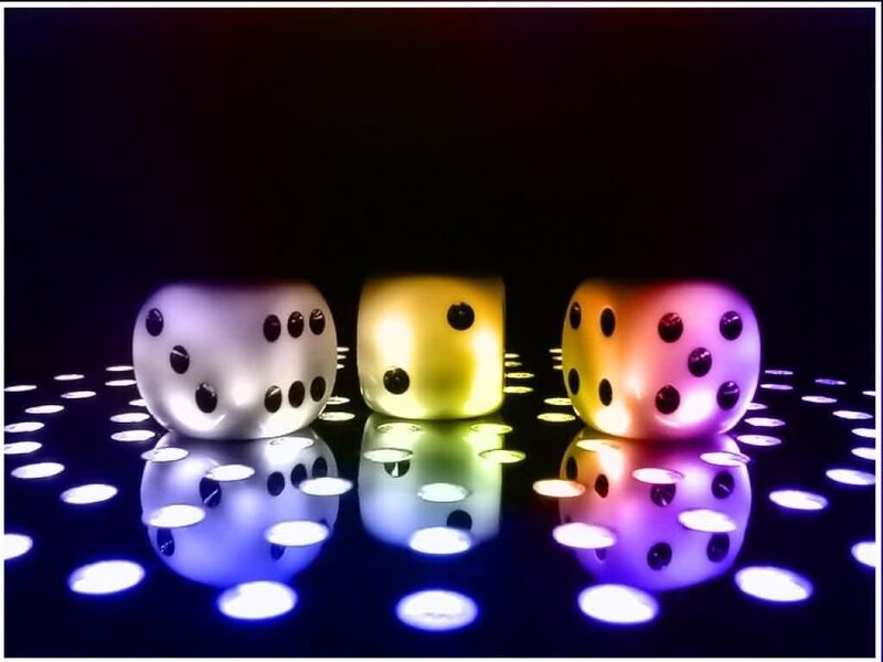 Colorful dice on reflective surface